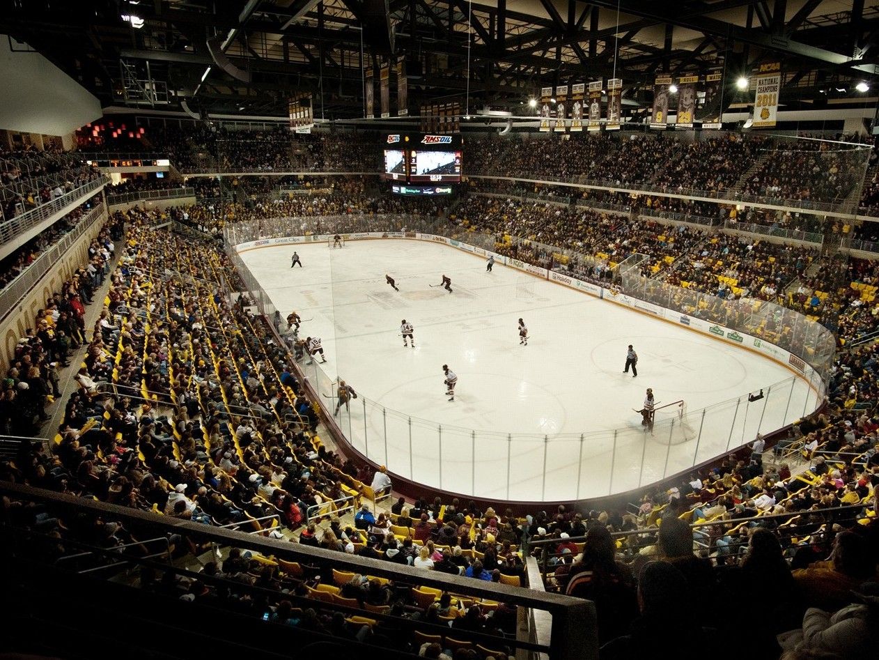 Vista aerea di un palazzetto dello sport affollato durante una partita universitaria di hockey su ghiaccio.